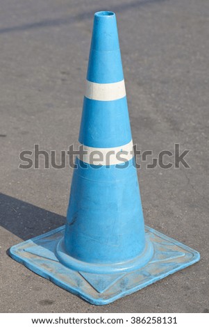 Blue traffic cone and shadow.
