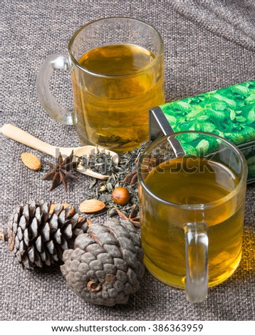 two cups of green tea with the pine cones on the table Royalty-Free Stock Photo #386363959