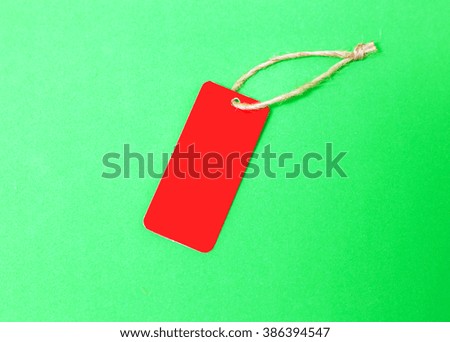 Red blank price tag isolated on green background 