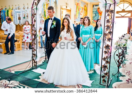 Wedding couple with bridesmaids stay at church under arch
