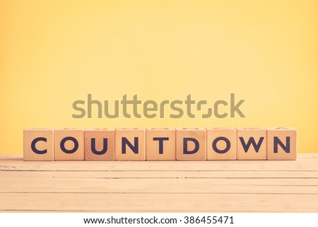 Countdown sign with wooden blocks on yellow background