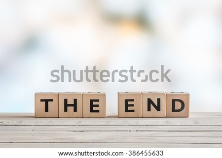 The end sign with wooden blocks on a table Royalty-Free Stock Photo #386455633