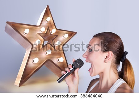  Girl with a microphone on the background of sign star.