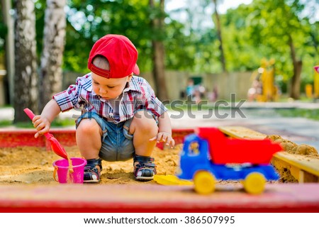child plays with sand  Royalty-Free Stock Photo #386507995