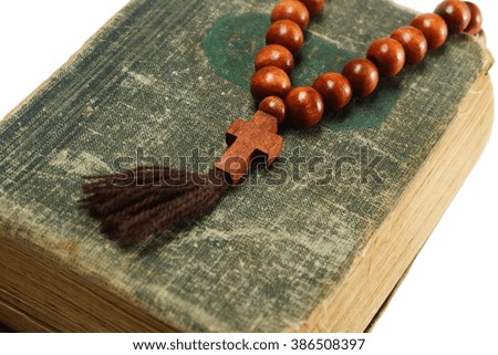 rosary beads on old book. white background
