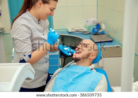 cute Woman dentist checks the teeth of her patient in the dental office. Medicine, dentist, health and stomatology concept