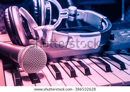 microphone,headphone on piano background.Blurred sound mixer.