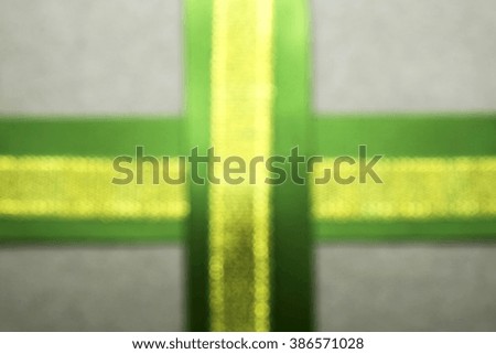 Blurred image of brown paper parcel/gift or present wrapping box with green and golden ribbons.
