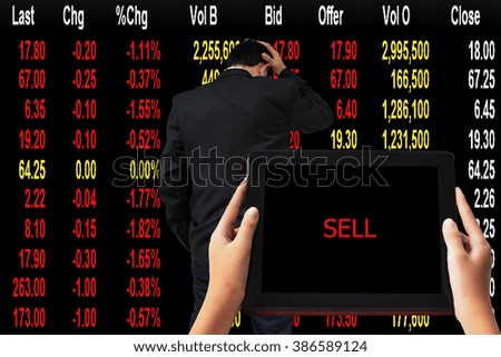Financial Concept. " SELL" words in red on tabled in hands and Young businessman his declining share. Bad business, economy in recession!