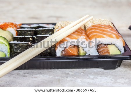 Salmon and avocado sushi in a black tray