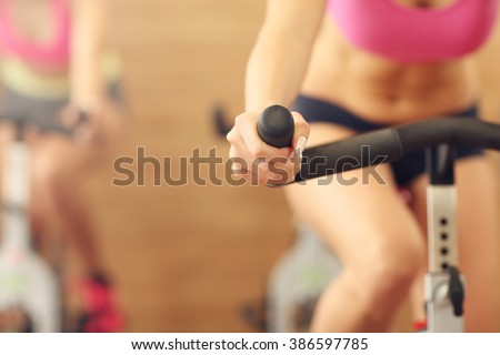 Midsection of sporty group of women on spinning class Royalty-Free Stock Photo #386597785