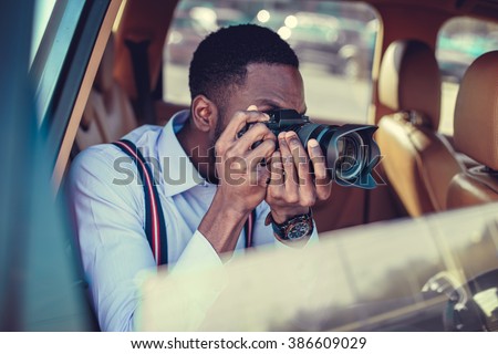 A blackman shooting on dslr from the car.