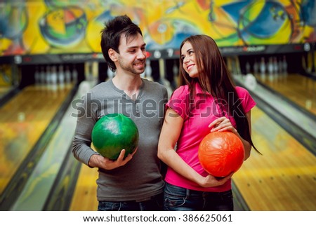 Cheerful friends at the bowling alley with the balls