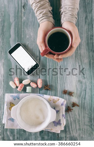 Smartphone and cup of strong coffee on wooden background. Cell phone with writing set with espresso