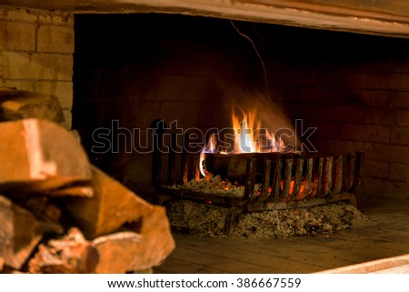 Traditional fireplace with burning firewood and charcoal in modern interior. Beautiful view of fire in fireplace create warm and cozy picture. As background for design