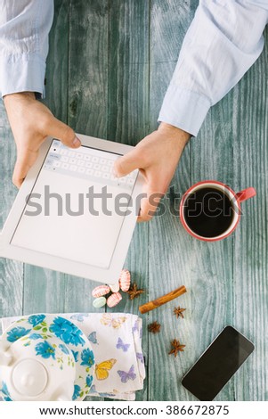 hand using mockup tablet similar to ipad style on wood desk white display with clipping path screen easy add image