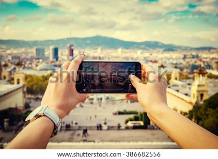 Young woman taking a picture of a city