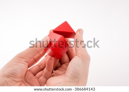 Hand making house with colorful cubes on a white background