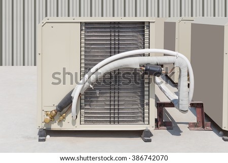 Air compressor or air condenser unit located on support outside building to heat released transferred to surrounding environment, Compressor is part of cooling function and air conditioning HVAC syste Royalty-Free Stock Photo #386742070