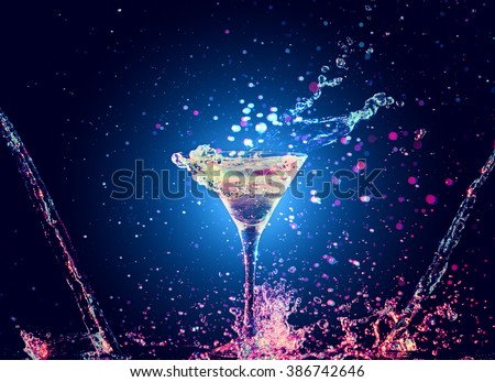 Colourful cocktail in glass with splash on the dark background