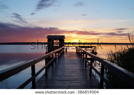 Sunset on the pier in the background of a large reservoir
