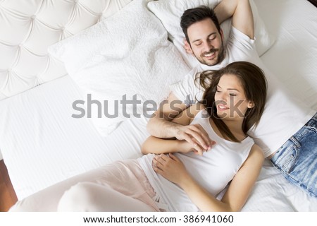 Young loving couple in the bed Royalty-Free Stock Photo #386941060