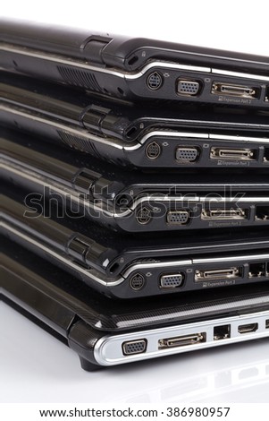 stack of old laptops awaiting repair isolated on white background
