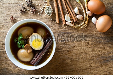 Eggs boiled in the gravy with spices on wooden background. Thai cuisine (Kai pa lo)