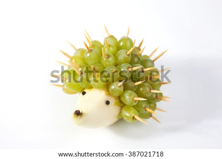 Food art creative concepts. Funny and cute hedgehog made of pear and green grapes isolated on a white background.