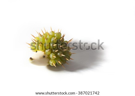 Food art creative concepts. Funny and cute hedgehog made of pear and green grapes isolated on a white background.