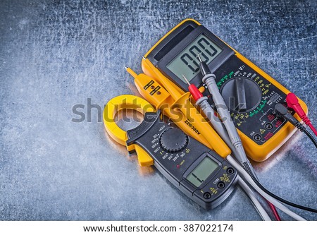 Digital clamp meter electric tester multimeter on metallic background. Royalty-Free Stock Photo #387022174