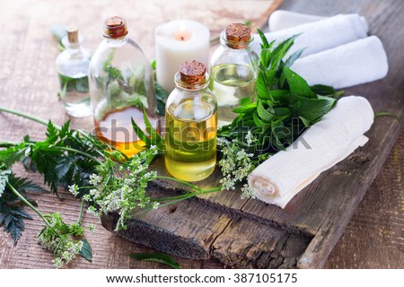 Organic essential aroma oil with  herbs on aged wooden background. Homeopathy. Selective focus.  Royalty-Free Stock Photo #387105175