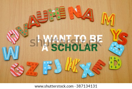 A word "i want to be a scholar" in a circle of alphabet letter with the wood background. copy space                        