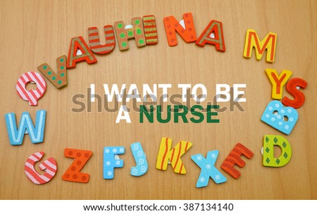 A word "i want to be a nurse" in a circle of alphabet letter with the wood background. copy space                        
