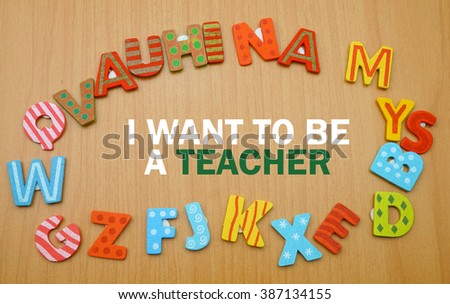 A word "i want to be a teacher" in a circle of alphabet letter with the wood background. copy space                        