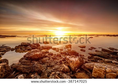 Beautiful sunset over sea, amazing peaceful beach landscape, picturesque view from stony seaside, beauty of nature