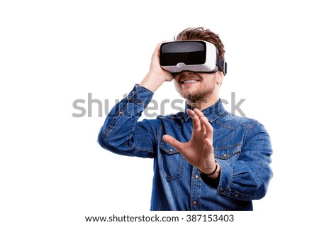 Man wearing virtual reality goggles. Studio shot, white backgrou Royalty-Free Stock Photo #387153403
