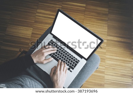 Top view of male hands using modern laptop with blank screen for your text message or content, man'?s hands using notebook computer and typing on keyboard while working at home
