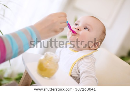 Close up of a mother feeding her baby  Royalty-Free Stock Photo #387263041