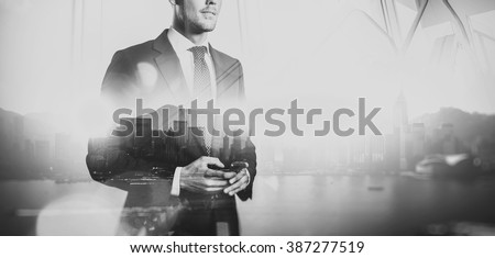 Black white photo of  businessman holding smartphone. Double exposure, city on the background. Wide