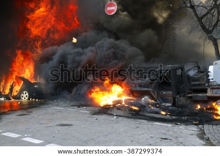 Riots in the city, citizens in conflict with the power harness tires and vehicles police disperse demonstrators in Europe, protesting people fighting for their rights, is also breaking the law Royalty-Free Stock Photo #387299374