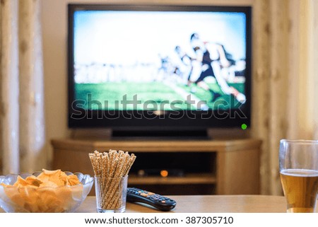 TV, television watching (American football match) on TV with snacks and alcohol - stock photo