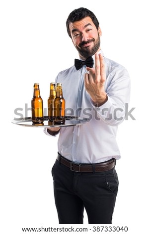 Waiter with beer bottles on the tray coming gesture