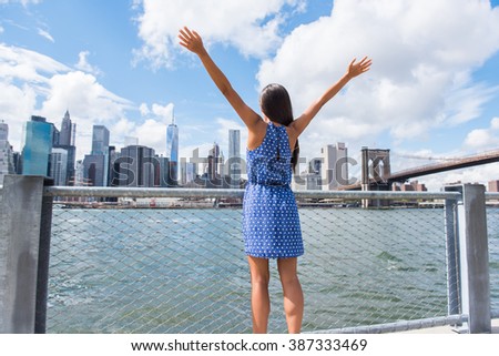 Happy free woman cheering at NYC New York city urban skyline with arms up raised in the sky. Success in business career, goal achievement or carefree freedom successful urban person concept.