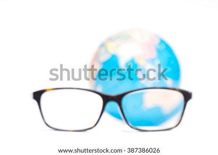 blurred image of eyeglasses and globe on white background