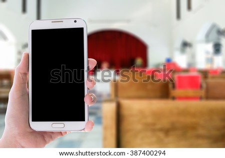 Girl use mobile phone, blur image in Church as background.