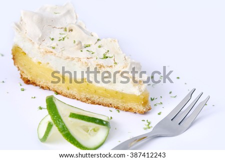 isolated piece of lemon meringue pie, tart, decorated with lime
