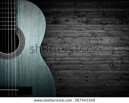 Part of a blue acoustic guitar on a gray wooden background