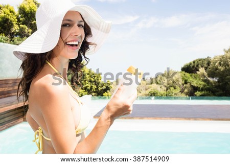 Portrait of beautiful woman smiling near poolside on a sunny day