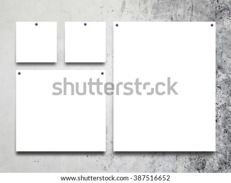 Close-up of four square and rectangular paper sheet frames with nails on grey weathered concrete wall background